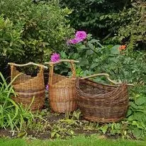 Set of willow baskets outdoors by planting beds