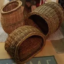 Willow baskets and a large woven basket on its side indoors