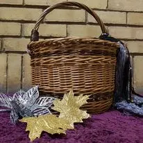 Handled willow basket displayed indoors with autumn leaves